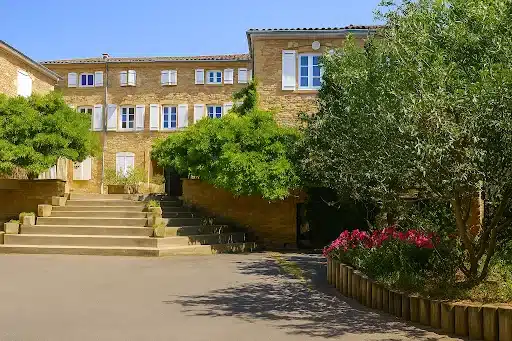 batiment en pierre jaune avec escalier menant a l entree mfr
