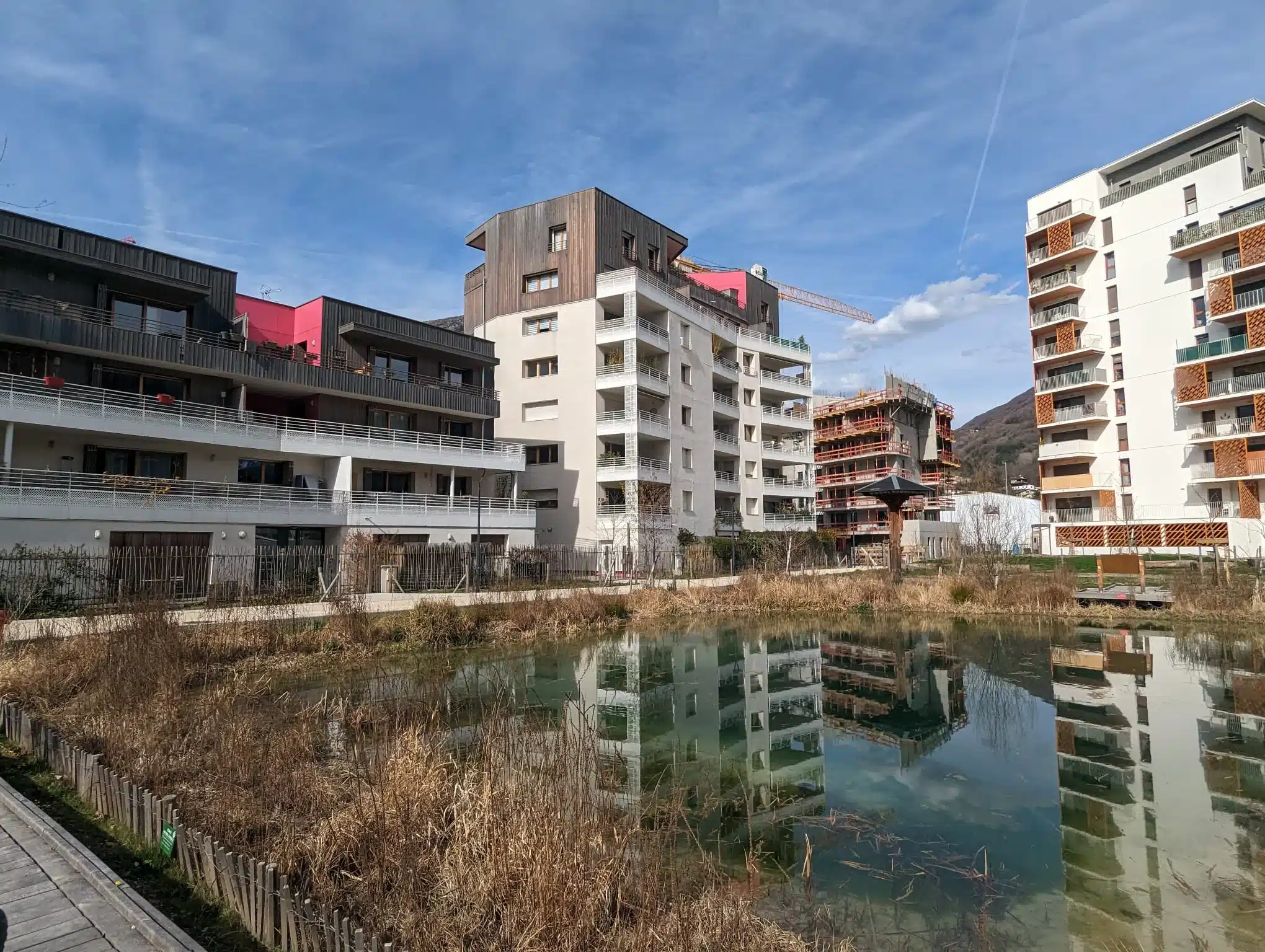 batiments modernes avec etang refletant le ciel bleu et les