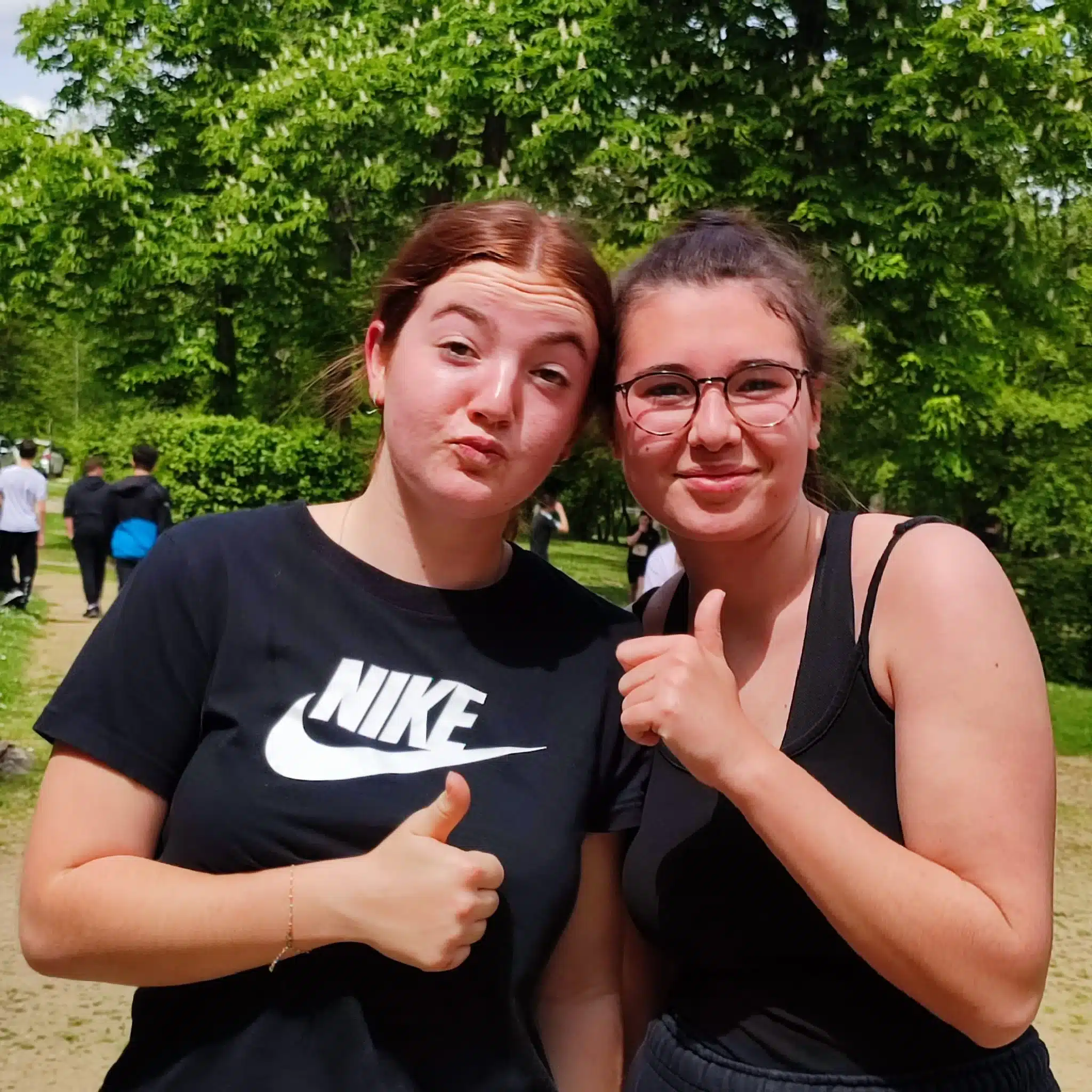 deux jeunes femmes souriantes font un pouce leve devant un a 1