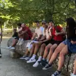 groupe d etudiants mfr souriants assis sur un tronc d arbre