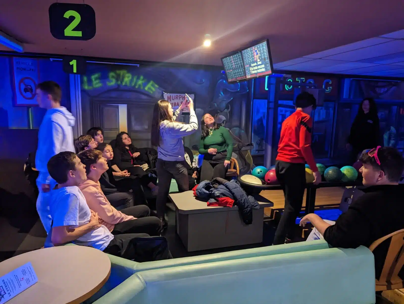 groupe de jeunes dans un bowling certains regardent une part