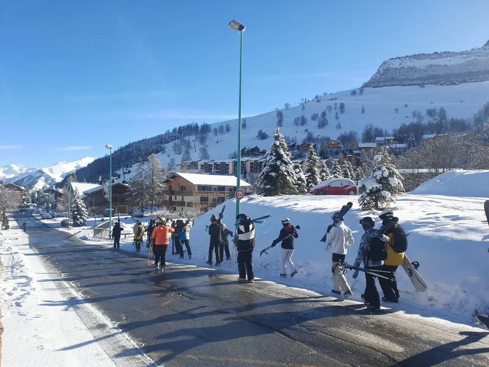 groupe de skieurs et snowboardeurs sur une route enneigee mf