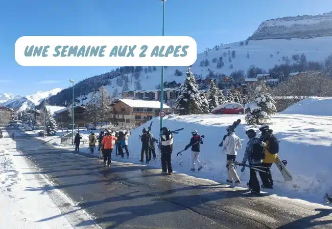 groupe de skieurs marchant sur une route enneigee a 2 alpes