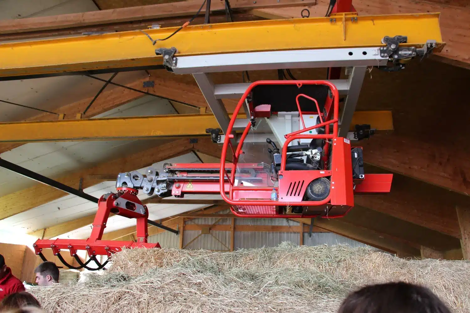 grue rouge pour manipulation de balles de foin dans une gran