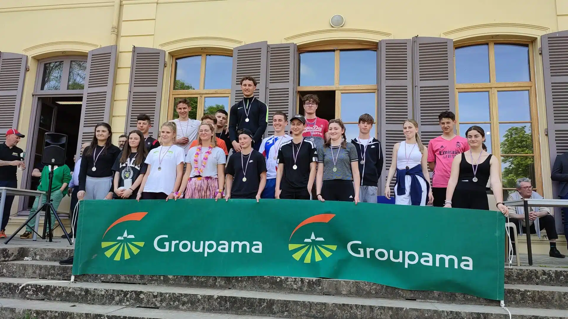 jeunes recompenses sur scene devant une banniere groupama mf