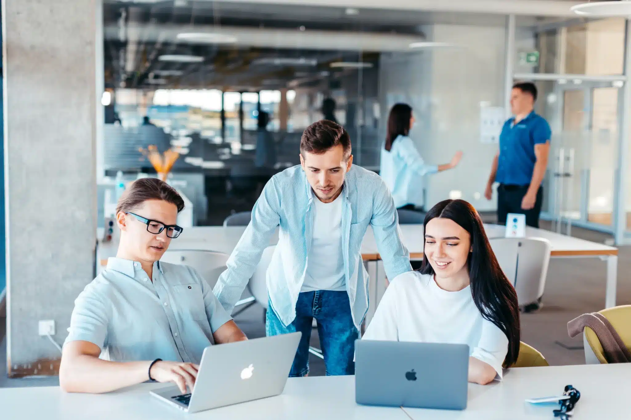 trois jeunes adultes travaillent sur des ordinateurs portabl